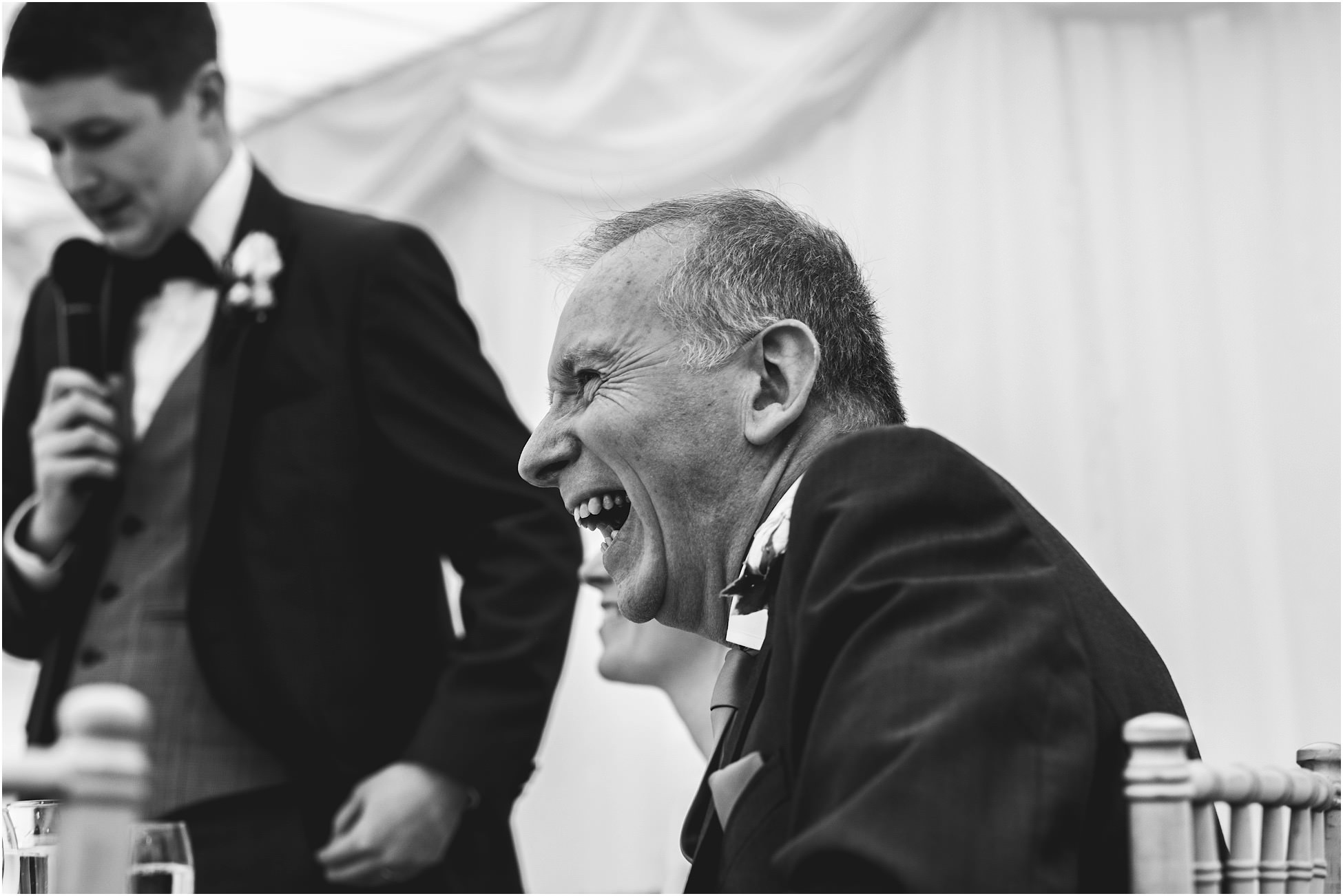 Father of the bride laughing during wedding speeches